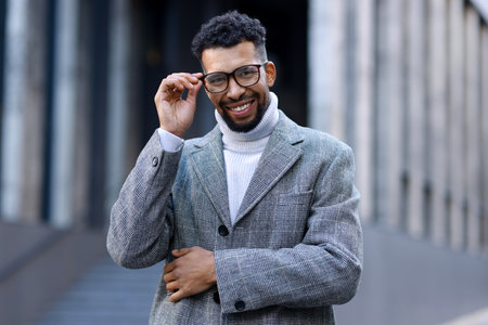 Portrait of smiling man in glasses and suit on city streetの写真素材