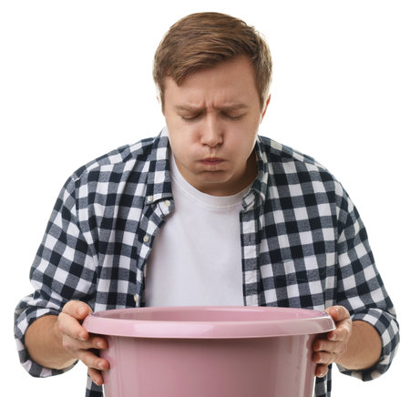 Young man with basin suffering from nausea on white backgroundの写真素材