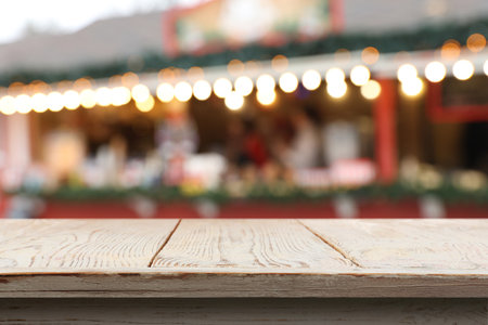 Empty white wooden table outdoors. Blurred Christmas stall on background. Space for designの写真素材