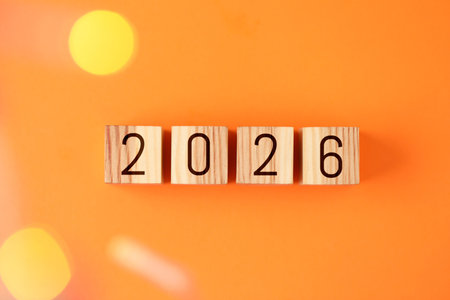 New 2026 year. Cubes with numbers on orange background, top view. Bokeh effectの写真素材