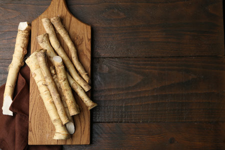 Fresh raw horseradish roots on wooden table, top view. Space for textの写真素材