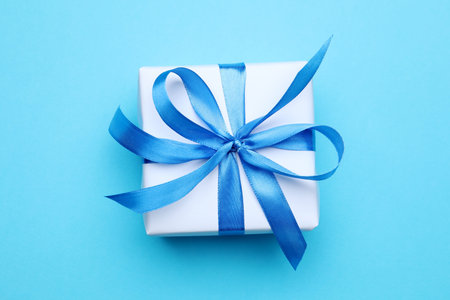 One gift box with ribbon on light blue background, top viewの写真素材
