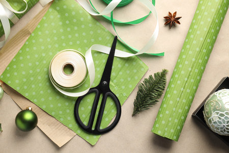 Gift wrapping materials and Christmas decor on kraft paper background, flat lay