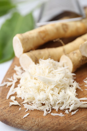 Grated horseradish, leaves and fresh roots on white table, closeupの写真素材