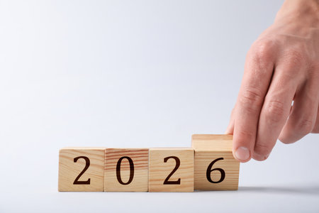 Man putting cube with number 6 on light background, closeup