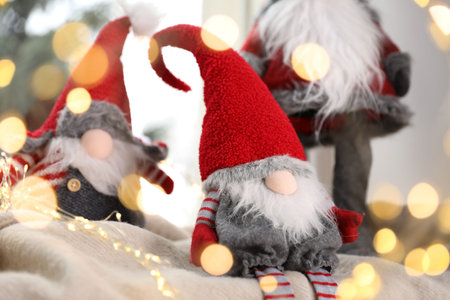 Christmas gnomes on blanket near window at home, closeup. Bokeh effectの写真素材
