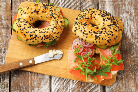 Delicious bagels with salmon on wooden table, top viewの写真素材