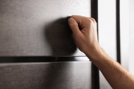 Man knocking on apartment door, closeup viewの写真素材