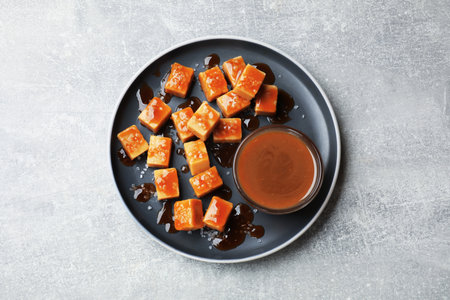 Tasty candies with salt and caramel sauce on gray textured table, top viewの写真素材