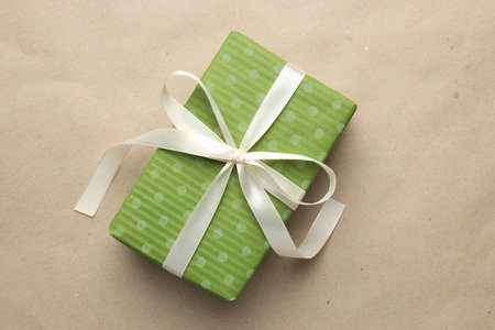 Decorated Christmas gift on kraft paper background, top view