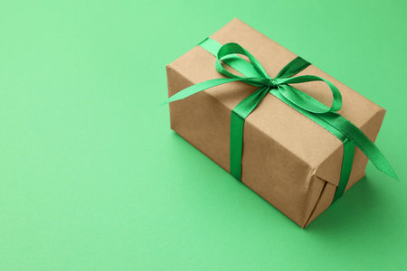 Beautiful gift box on green background, closeup. Space for textの写真素材