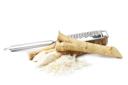 Grated horseradish, grater and roots isolated on whiteの写真素材