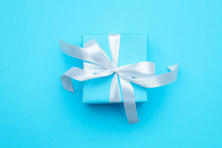 One gift box with ribbon on light blue background, top viewの写真素材
