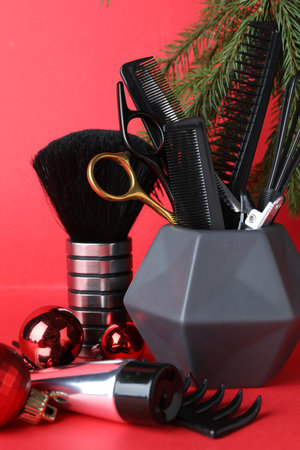 Different hairdresser's tools and Christmas decor on red background, closeupの写真素材