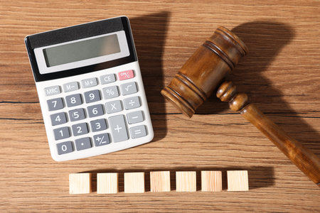 Alimony. Blank cubes, calculator and judge's gavel on wooden table, flat lay