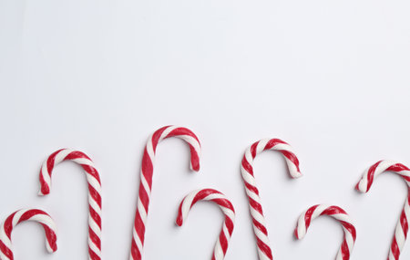Merry Christmas and Happy New Year. Tasty candy canes on white background, flat lay. Space for textの写真素材