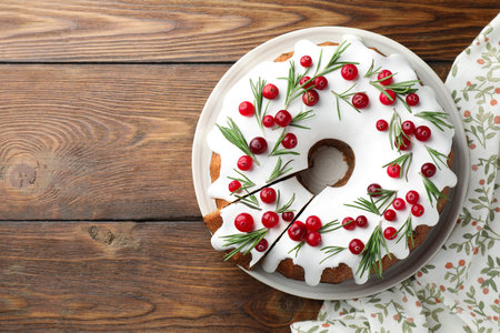 Tasty Christmas cake with cranberries on wooden table, top view. Space for textの写真素材
