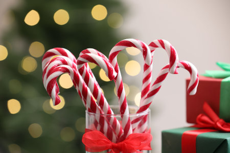 Candy canes in glass against blurred lights, closeup. Christmas treatの写真素材
