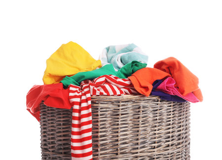 Wicker basket with laundry isolated on whiteの写真素材