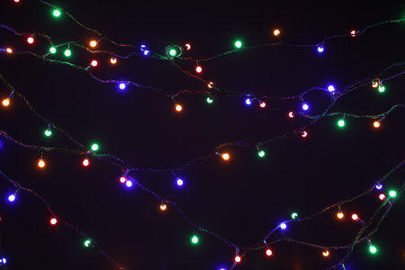 Glowing bright Christmas lights on dark background