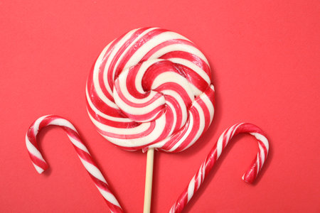 Christmas treat. Lollipop and candy canes on red background, top viewの写真素材