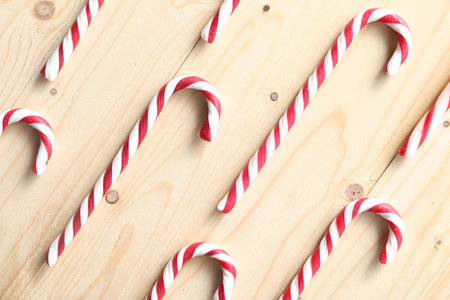 Candy canes on wooden table, flat lay. Christmas treatの写真素材