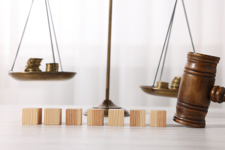 Alimony. Blank cubes, judge's gavel, scales and coins on wooden tableの写真素材