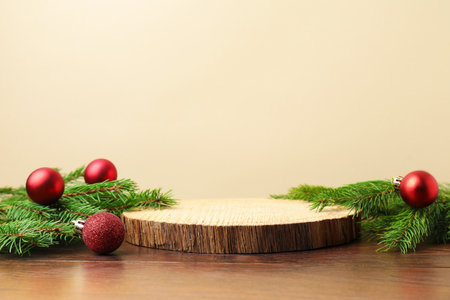 Empty podium and Christmas decor on wooden table against beige background, closeup. Space for textの写真素材