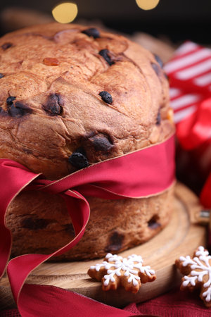Christmas food. Delicious Panettone cake, gingerbread cookies and decor on table against blurred lights, closeup. Bokeh effectの写真素材