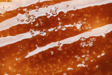 Delicious caramel sauce with salt as background, top viewの写真素材