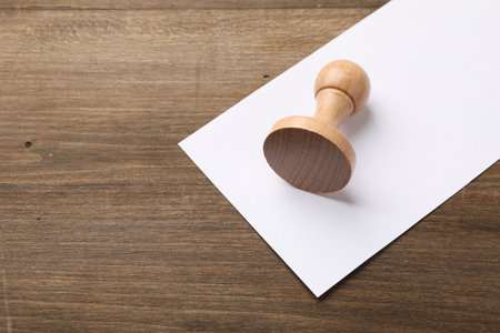 One wooden stamp and blank sheet of paper on table, top view. Space for textの写真素材