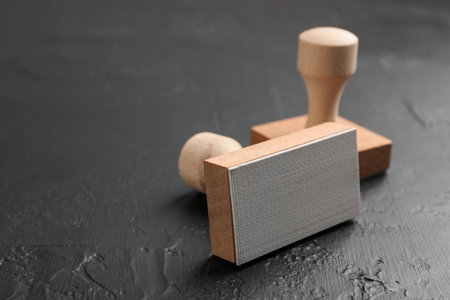Two wooden stamps on dark textured table, closeup. Space for textの写真素材