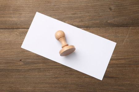One wooden stamp and blank sheet of paper on table, top view. Space for textの写真素材