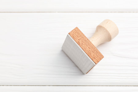 One wooden stamp on white table, top view. Space for textの写真素材