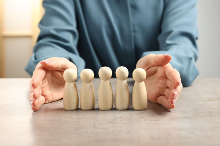 Woman protecting human figures at light table, closeupの写真素材