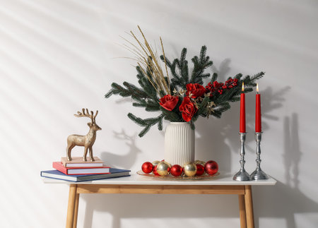 Different Christmas decor on console table near white wall indoorsの写真素材