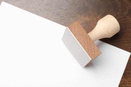 One wooden stamp and blank sheet of paper on table, top view. Space for textの写真素材