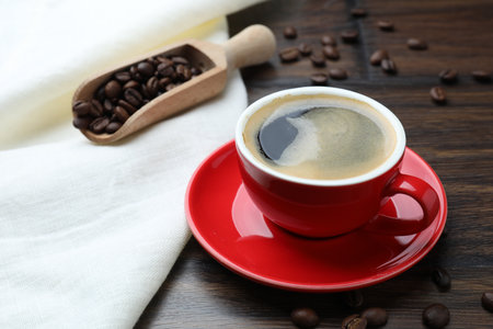Aromatic coffee in cup and beans on wooden table, closeupの写真素材