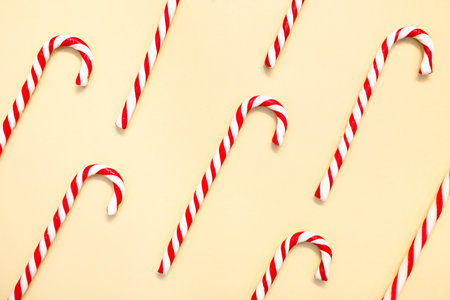 Candy canes on beige background, flat layの写真素材