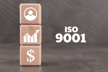 ISO 9001 Quality management systems. Wooden cubes with different icons on gray backgroundの写真素材