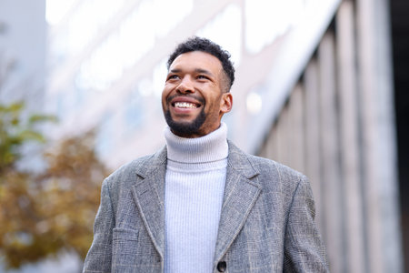Smiling man in suit on city street, low angle viewの写真素材