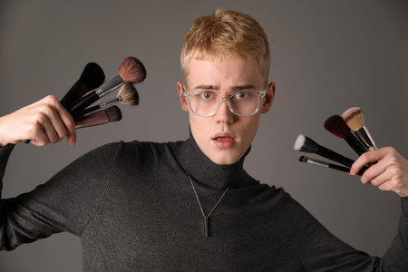 Makeup artist with set of brushes on gray backgroundの写真素材
