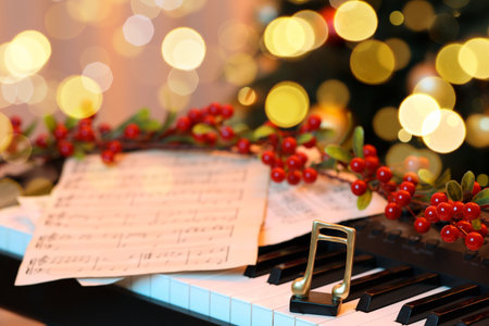 Golden music note, sheets and Christmas decor on piano indoors, closeup. Bokeh effectの写真素材