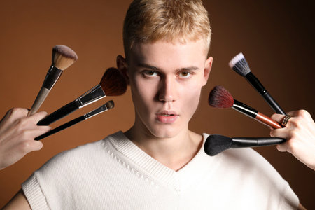 Makeup artist with set of brushes on brown backgroundの写真素材