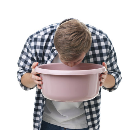 Young man with basin suffering from nausea on white backgroundの写真素材