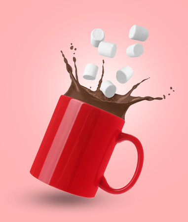 Marshmallows falling into cup with hot cocoa on pink backgroundの写真素材