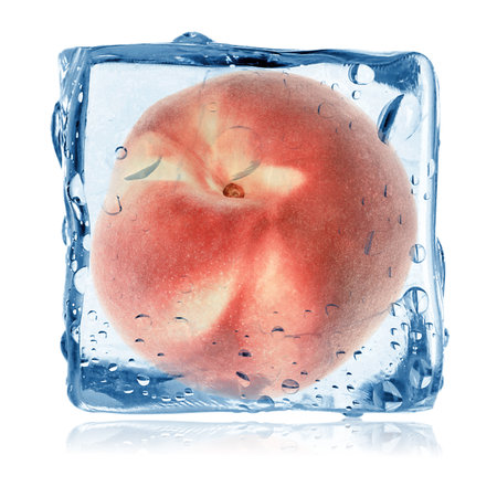 Fresh peach in ice cube isolated on whiteの写真素材