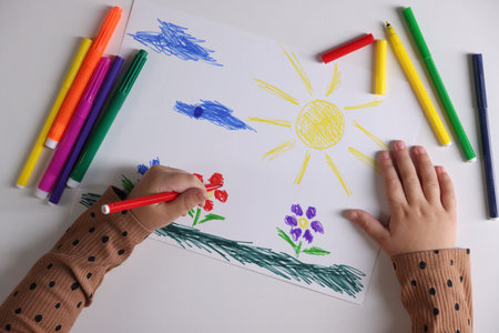 Cute little girl drawing with felt pen at white table, top viewの写真素材