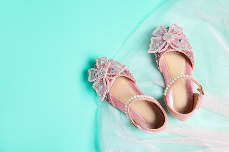 Pair of stylish kid's shoes and skirt on turquoise background, top view. Space for textの写真素材