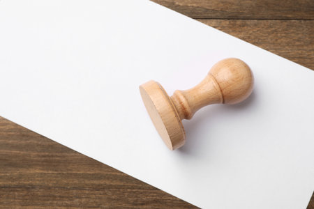 One wooden stamp and blank sheet of paper on table, top view. Space for textの写真素材